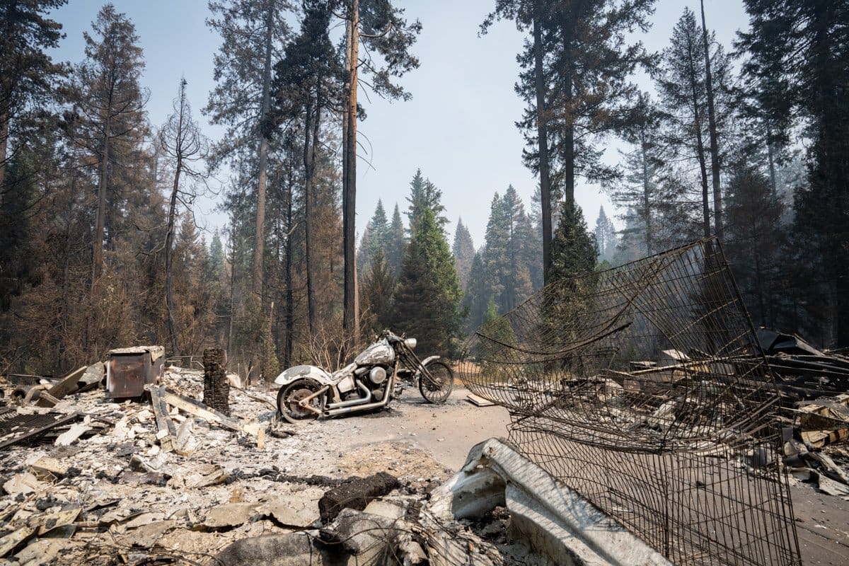 documentary photography of california wildfires that shows the remains of a charred motorcycle sitting in the ash and rubble