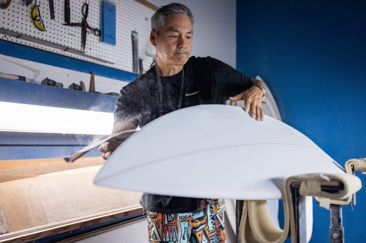 a craftsman sands and builds his own surfboard