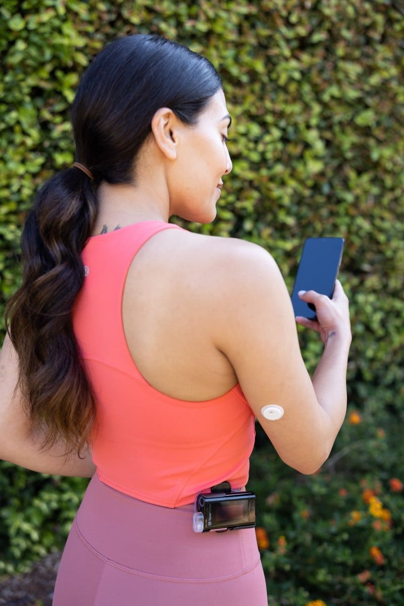 Commerical Photography of a woman monitoring her glucose levels with the Abbott CGM Sensor