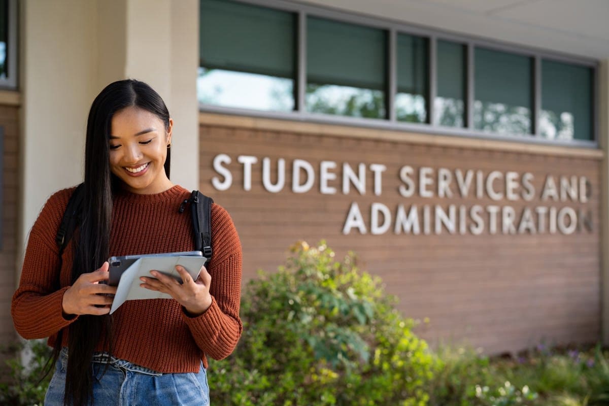 a student reads outside the offices on her campus in this commerical photograph for CA Community Colleges