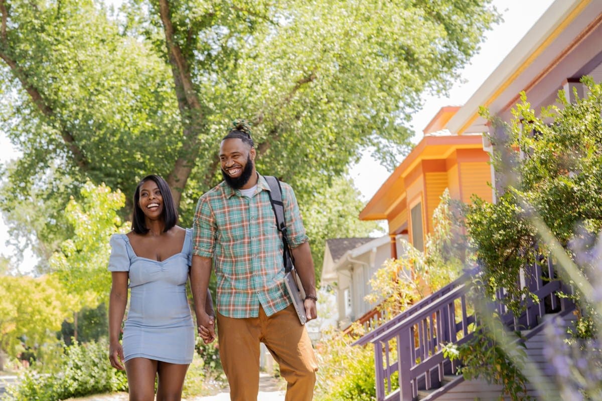 a couple smiles while walking to campus in this commercial photo shoot