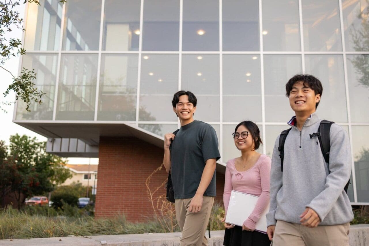 Commercial Photography of Students smiling as they walk on campus together.