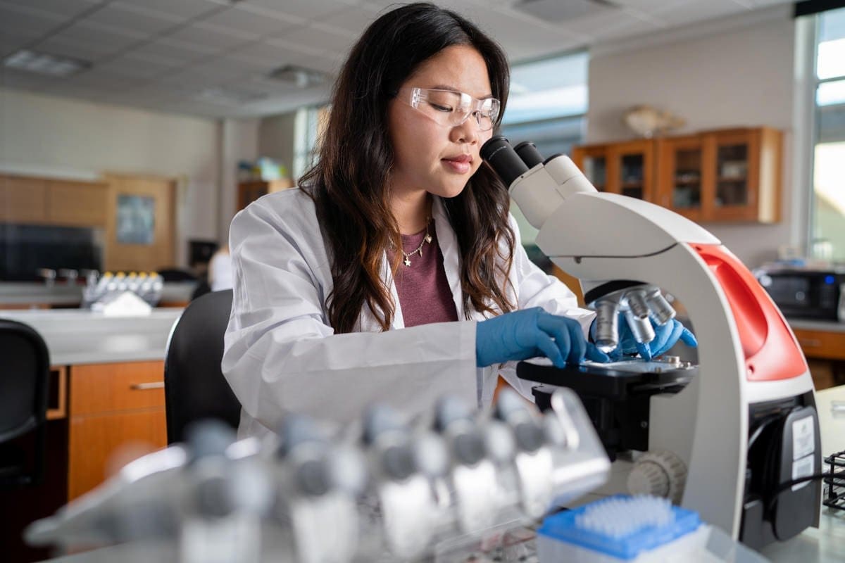 a student uses a microscope in this commerical photograph for CA Community Colleges