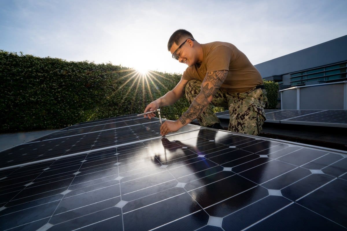 a student adjust solar panels in this commercial photograph for CA Community Colleges