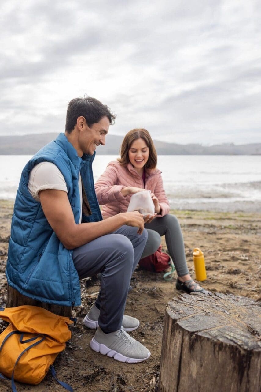 Outdoor lifestyle photography of a couple enjoying a snack on the shores of lake tahoe