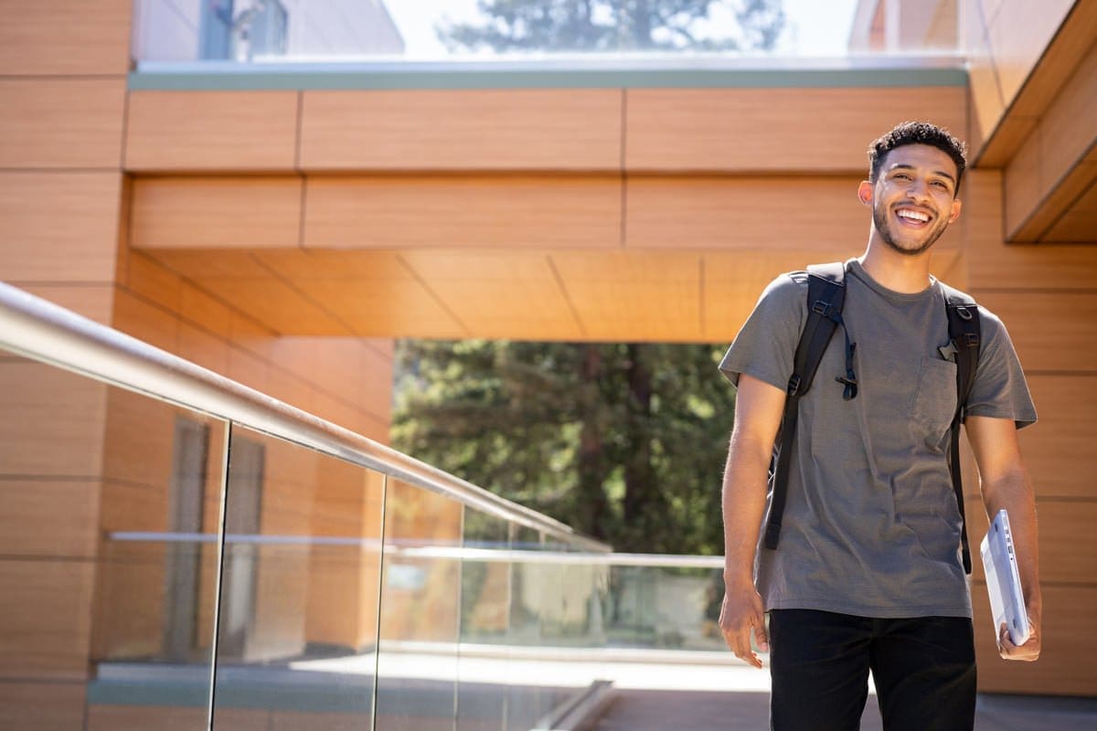 Commercial photograph of a student with his laptop on campus